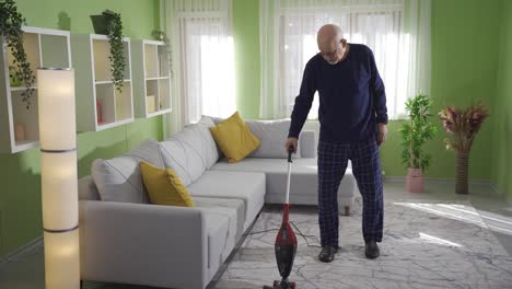 unhappy and depressed old man cleaning his house alone.