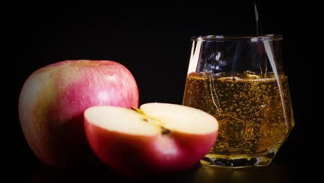 jugo de manzana derramado junto a manzanas enteras y cortadas en rodajas