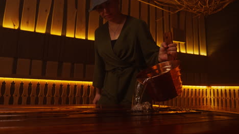 woman pouring hot water into a traditional wooden bath