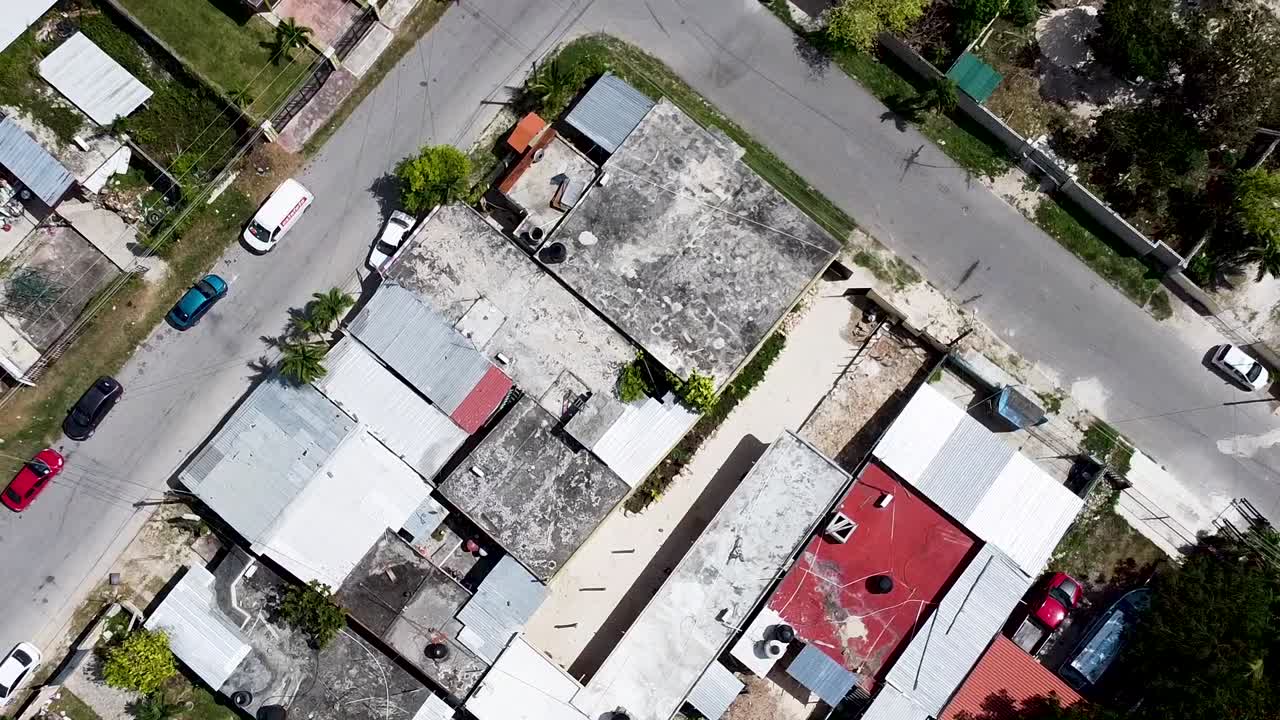drone aéreo subiendo y mirando directamente hacia un pequeño barrio pobre en un pequeño pueblo en quintana roo, méxico - bacalar