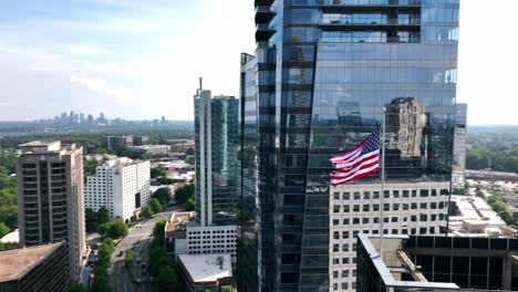 cinematic drone shot of the american flag waving at building top, atlanta, georgia, usa