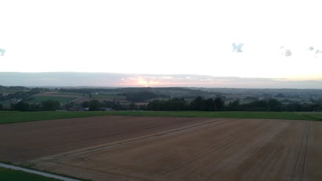 rising above crop fields by a small town in valley, golden hour