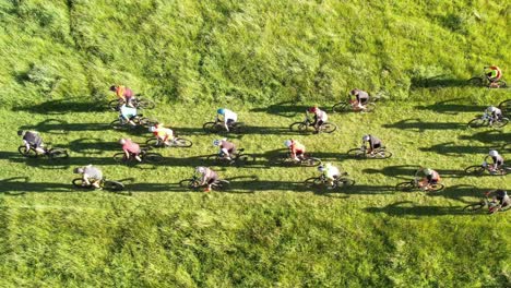 aerial tracking of race start as mountain bike riders sprint towards first corner - halswell quarry park, christchurch