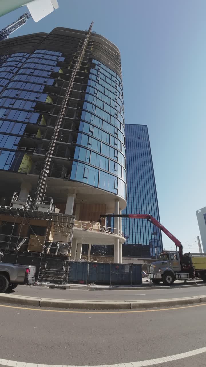 Modern Skyscraper Under Construction with Crane and Urban Traffic