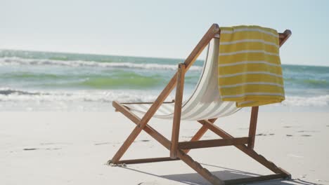 Close-up-of-deck-chair-and-towel-on-beach,-in-slow-motion,-with-copy-space