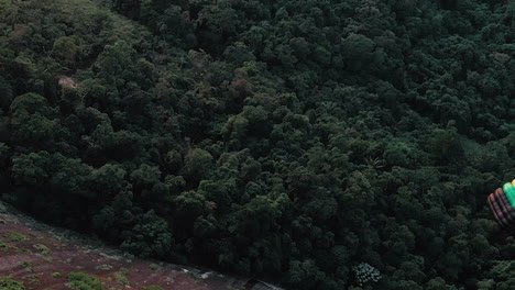 Aerial-View-Of-Parachuter-Gliding-Over-Lush-Green-Forest-In-Rio-De-Janeiro