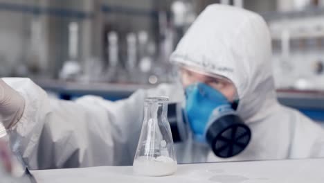 a scientist in a medical laboratory pours fluid