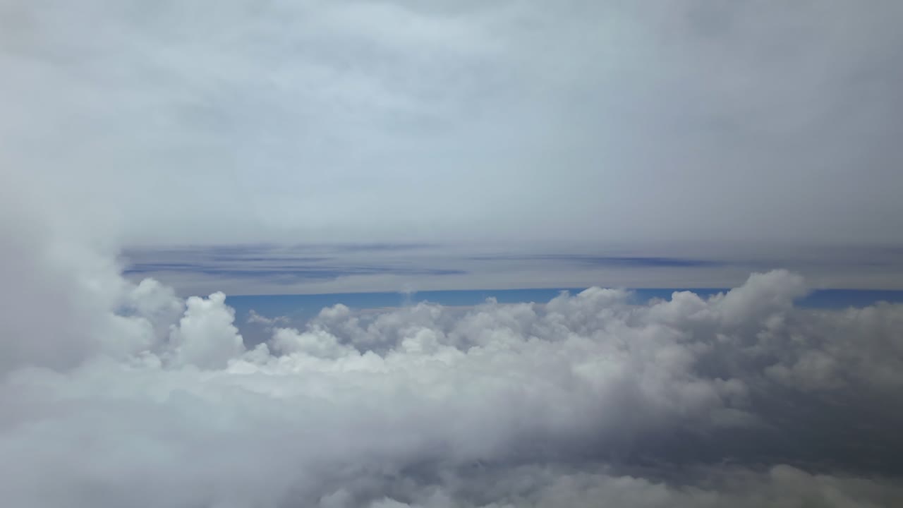 An immersive pilot’s view while flying through a dreamy cloudscape between layers of ethereal clouds at supersonic speed.