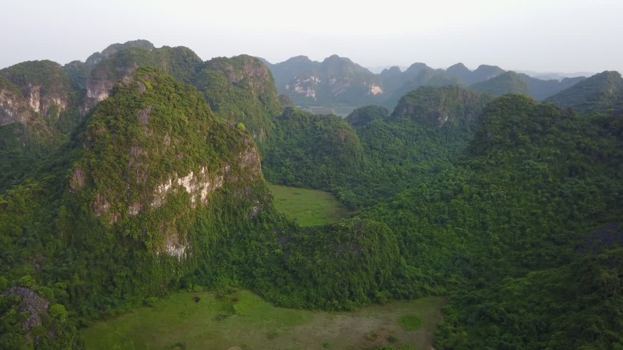 Soar above the breathtaking landscape of Ninh Binh, Vietnam, with this aerial view of its incredible limestone rock formations, revealing stunning peaks and lush green valleys.