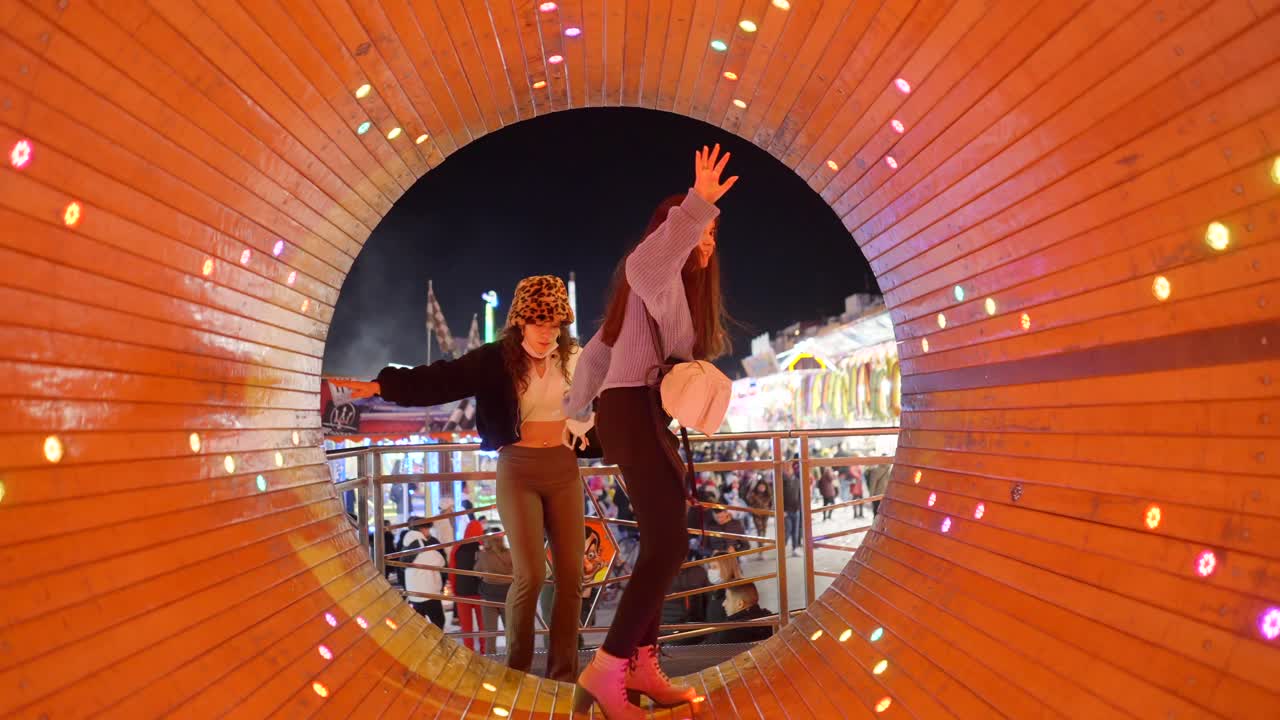 Teenage girls having fun in a tunnel at a fair