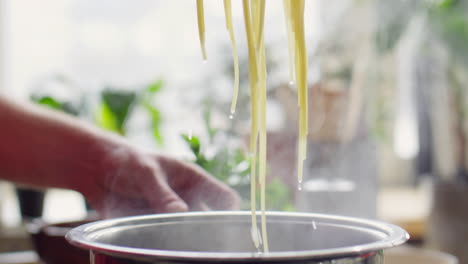 putting cooked spaghetti in colander