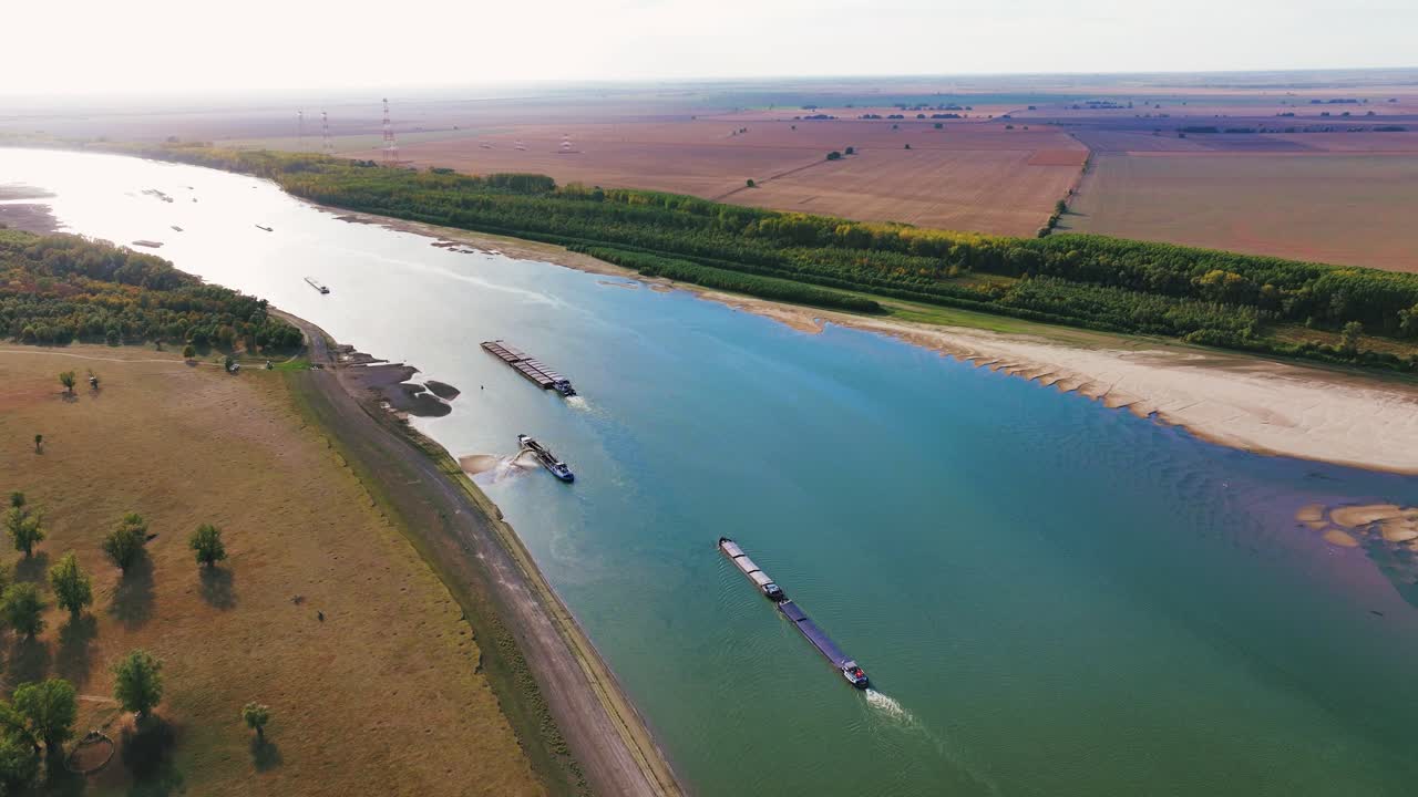 Aerial wide shot of a dredger unloading dredged sand on a big river, sunny day