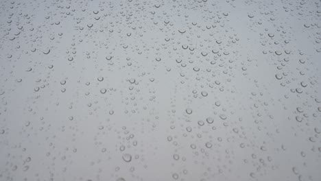 rainy glass as rain drops hits a window during a gloomy and overcast weather