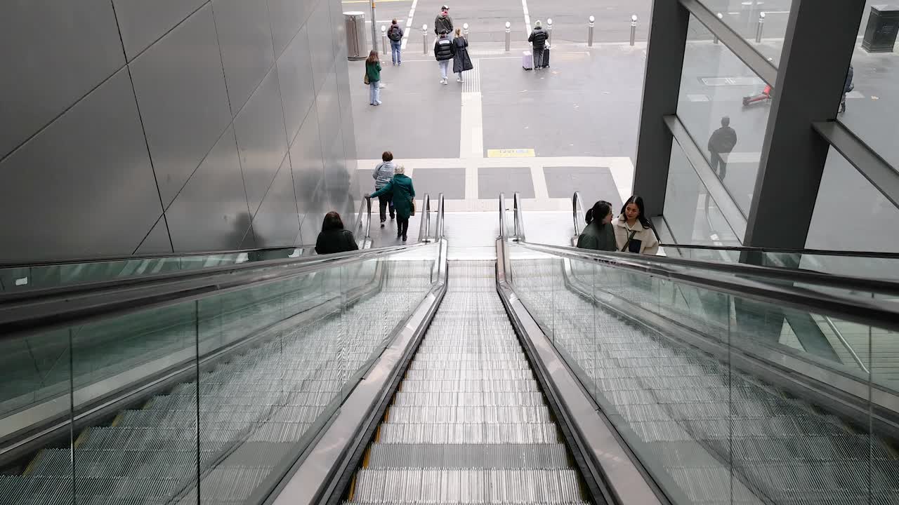 Personer kører op ad en rulletrappe i Melbourne