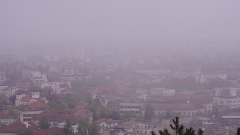 4K-footage-of-the-town-of-Vratsa,-Bulgaria,-and-the-surrounding-mountain-Stara-Planina-,-while-a-deep-fog-covers-the-town
