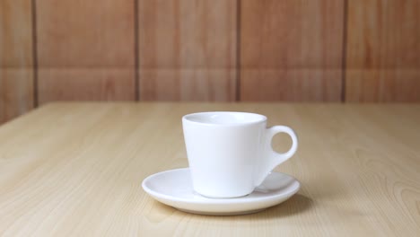 a cup sits on a wooden table