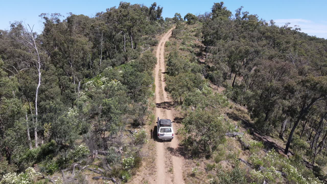 disparo de un dron alto de un toyota 4wd conduciendo por una montaña en el monte, cerca del lago eildon victoria australia