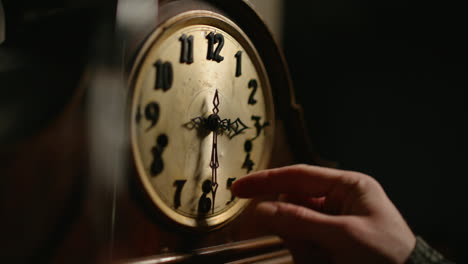 la mano cambia la hora en un viejo reloj mecánico