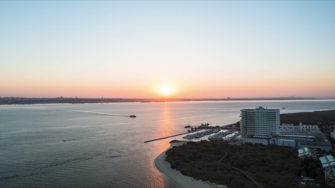청록색 물이 있는 도시와 모래 해변의 공중 전망, 해안에 여객선