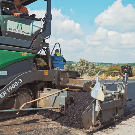 modern machinery for laying fresh asphalt. roadworks on a highway. paver machines pressuring hot asphalt on the road. road construction works.
