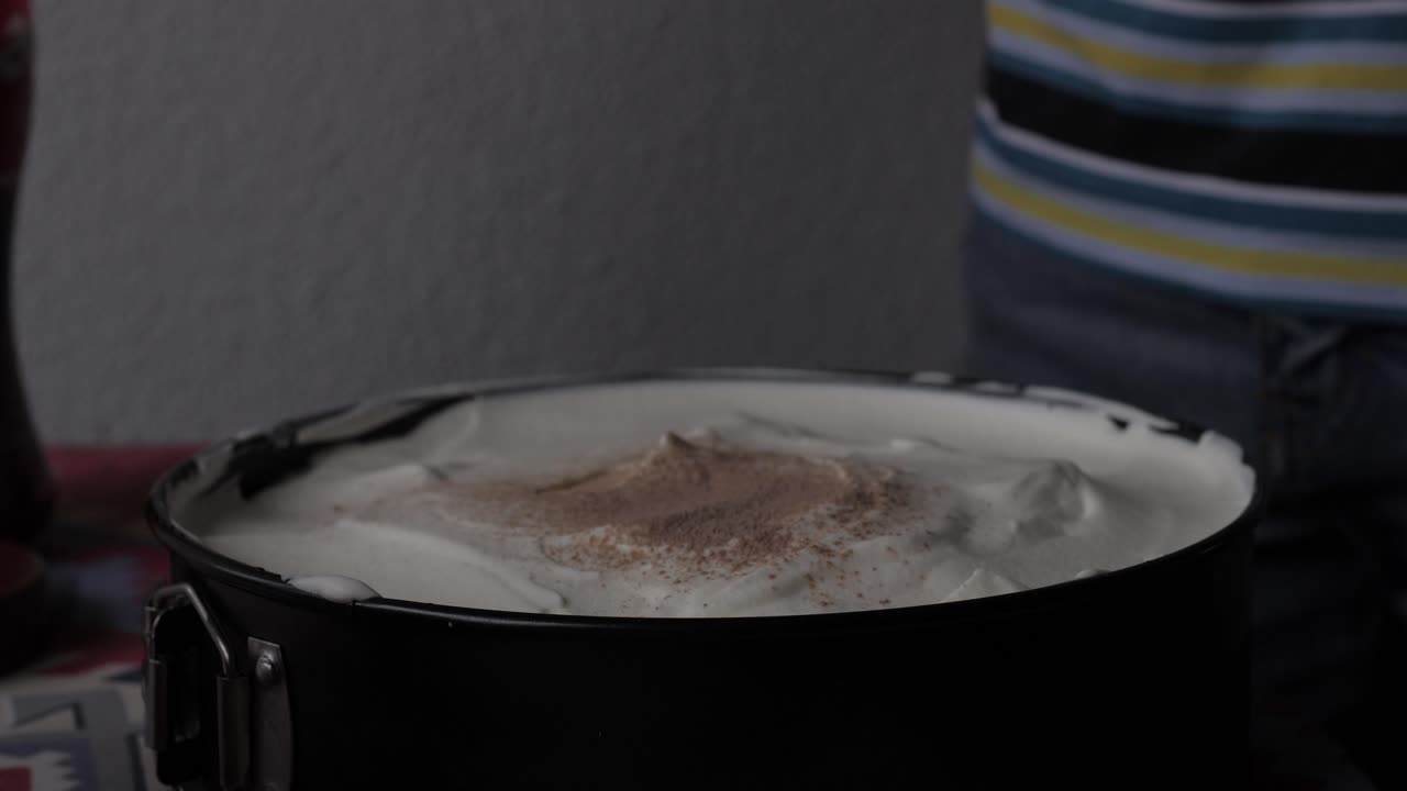 Espolvoreando chocolate sobre un pastel mientras se hornea en casa