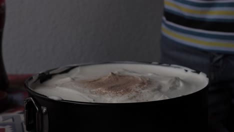 espolvorear chocolate en el pastel mientras hornea en casa