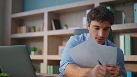 it manager doing research at workplace closeup. thoughtful man making notes