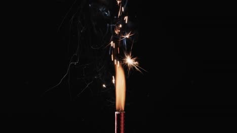 video of torch with yellow flame and sparks and copy space on black background