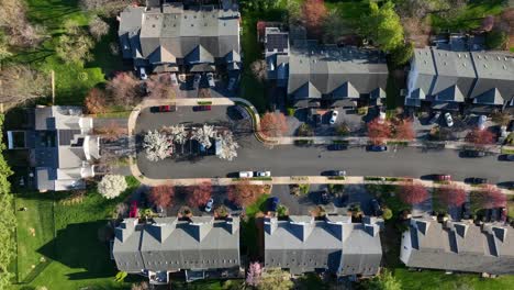 high top-down aerial shot of townhouses in quaint neighborhood cul de sac in spring