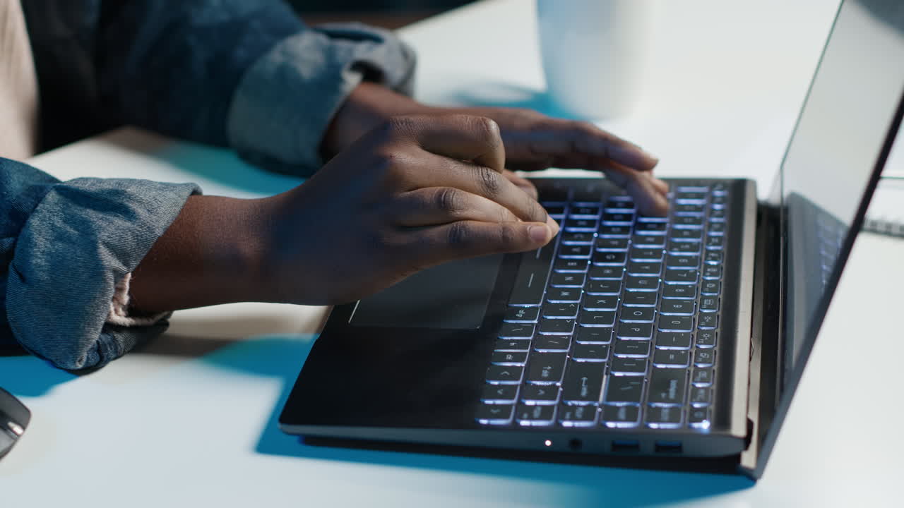 Person Typing on Laptop at Night