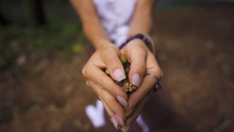 woman holding flower in her hands, standing in a jungle