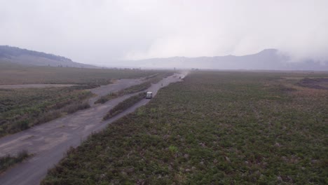 Jeeps-and-bikes-are-cruising-on-dirt-road-Mount-Bromo,-Indonesia---Tourist-Attraction,-Aerial