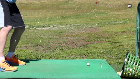 hombre practicando el swing de golf en el campo de manejo