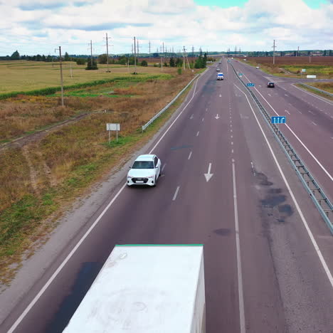 aerial view on a white audi moving slowly on highway. beautiful car driving on the first line of wide road.