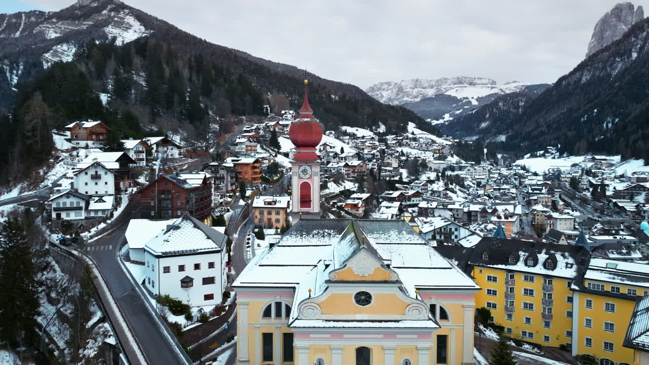 Aerial drone view of the Ortisei town covered in snow, within the Dolomites, in northern Italy