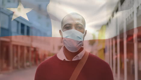 animation of flag of chile waving over man wearing face mask during covid 19 pandemic