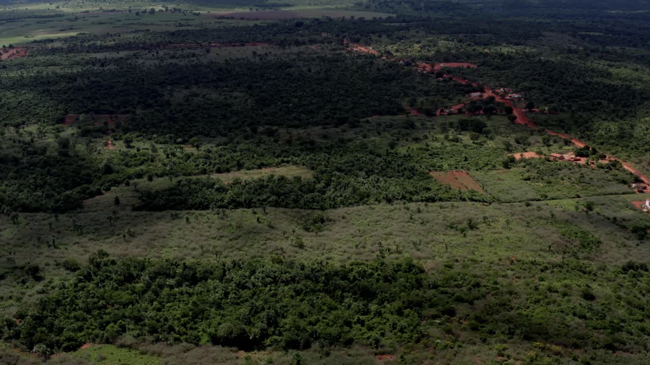 브라질 북부의 차파다 디아만티나 국립공원에 있는 작은 붉은 흙길과 화창한 여름날, 아름다운 오른쪽 트럭을 타고 브라질 시골의 공중 드론 샷을 기울입니다.