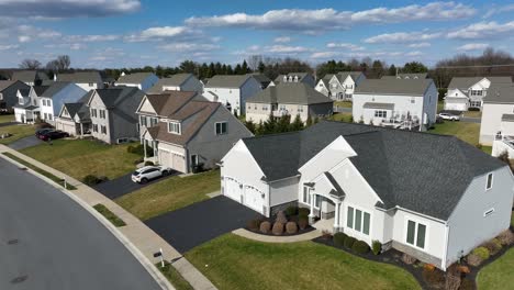 uniform subdivision of tan brown homes with manicured lawns, blue sunny day