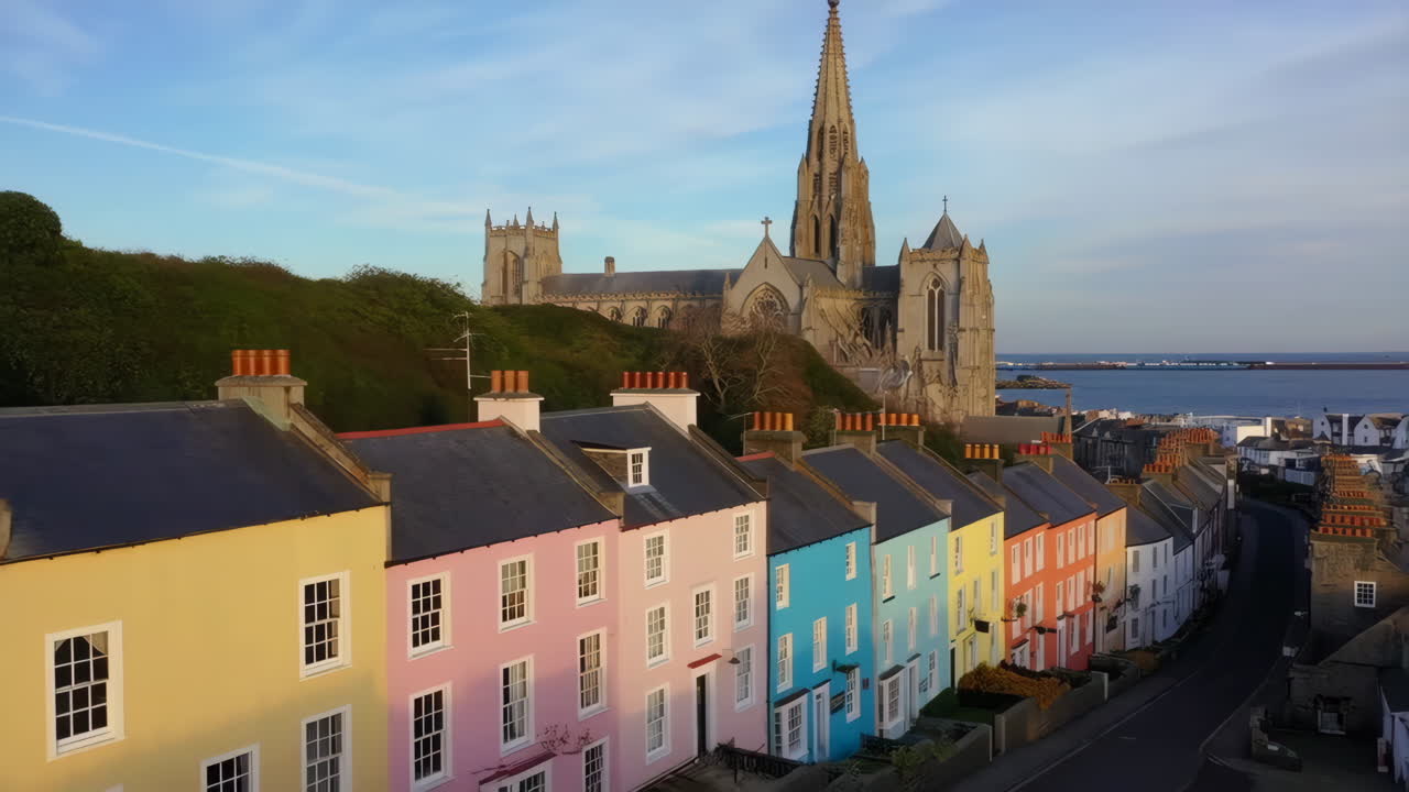 Colorful houses and a grand cathedral overlooking a coastal town