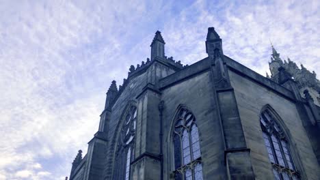 Slow-moving-clouds-moving-above-a-church-and-statue,-on-a-cold-and-cloudy-day-in-Scotland