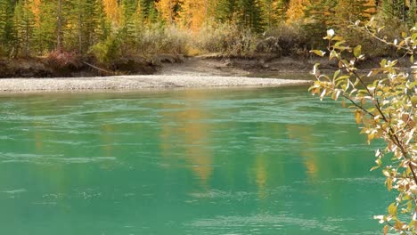 panning from the bow river to mountain peaks in canmore, alberta