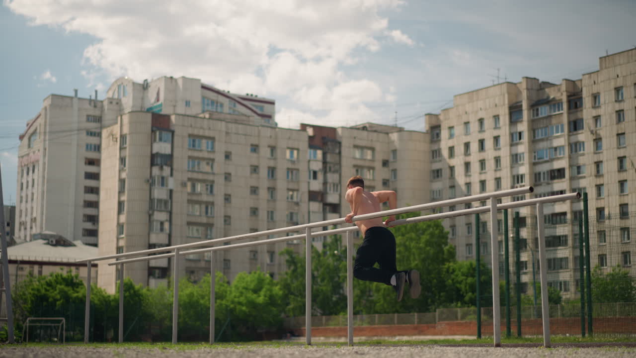흰색 옷을 입은 남자가 야외에서 균형을 잡는 연습을 하고 있어요. 침착한 남자가 아파트 건물과 나무 옆에서 꾸준한 속도를 유지하며, 집중하는 한 사람이 도시와 자연 환경 속에서 난간 위에서 균형을 잡는 연습을 하고 있습니다.