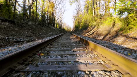 Drone-flying-over-entire-length-of-vacant-train-track,-running-parallel-to-each-other-on-bright-sunny-day