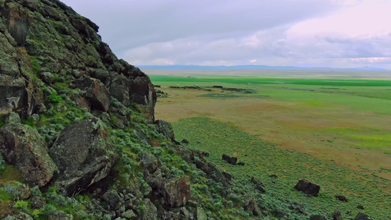 미국 유타 중부의 15번 주간 고속도로 근처에서 흐린 날 빠르게 검은 바위가 많은 푸른 언덕의 공중 드론 영상