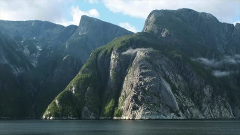 dramatic huge granite rock wall cliff rises directly out of the ocean