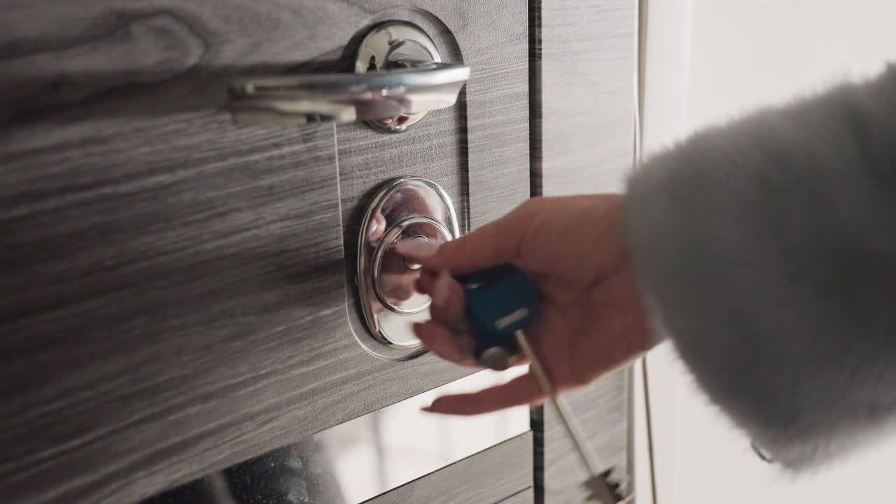 Sblocco con un sottile movimento della mano. Dolce giro della chiave per aprire la porta. Scena tranquilla della chiave che gira nella serratura per sbloccare la porta. Atto intimo di girare la chiave per ottenere l'accesso in un ambiente domestico calmo.