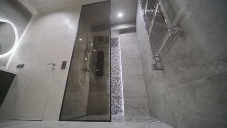 modern bathroom with wide walk-in shower, featuring a rain showerhead, detailed tile work, and a backlit niche for a sophisticated look