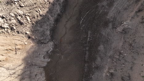 Aerial-birdseye-of-dry-riverbed-in-Sau-dam,-Catalonia,-Spain