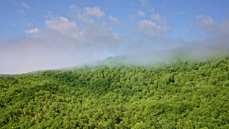 elevated drone shot of mist blanketing the smoky mountains in nc