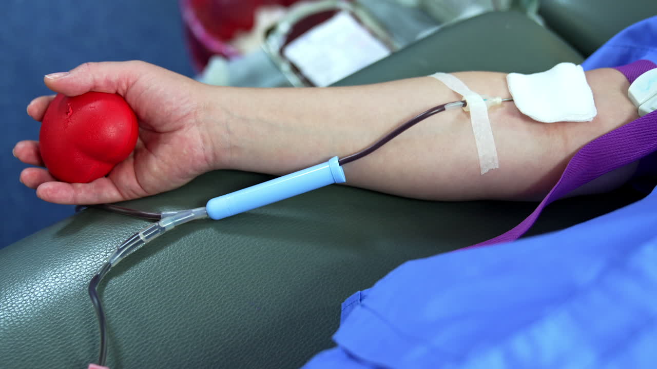 Iv drip is inserted in donor's vein. Close up. Blood donation concept in the hospital.